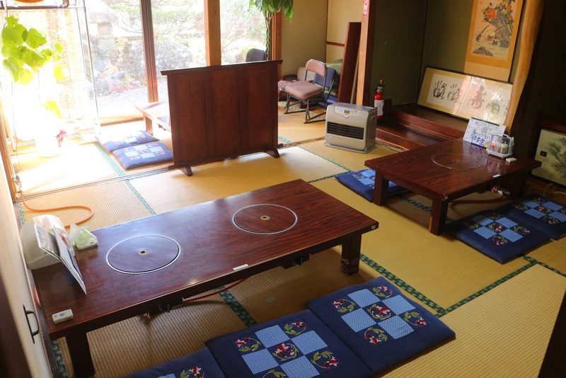 座卓と青い座布団が並ぶ、明るいお座敷